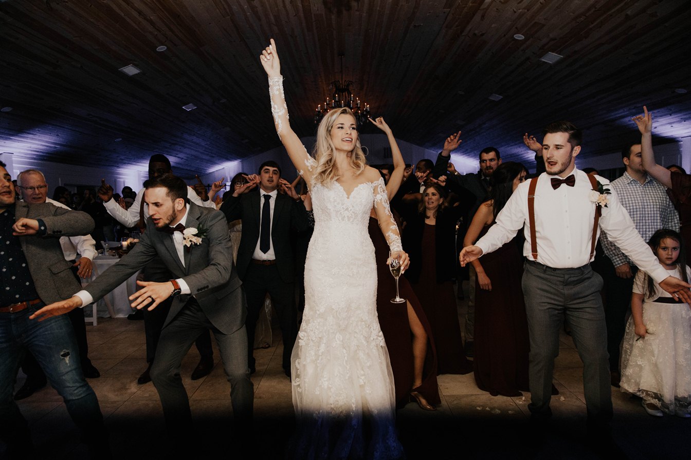 a bride with a drink dancing with others